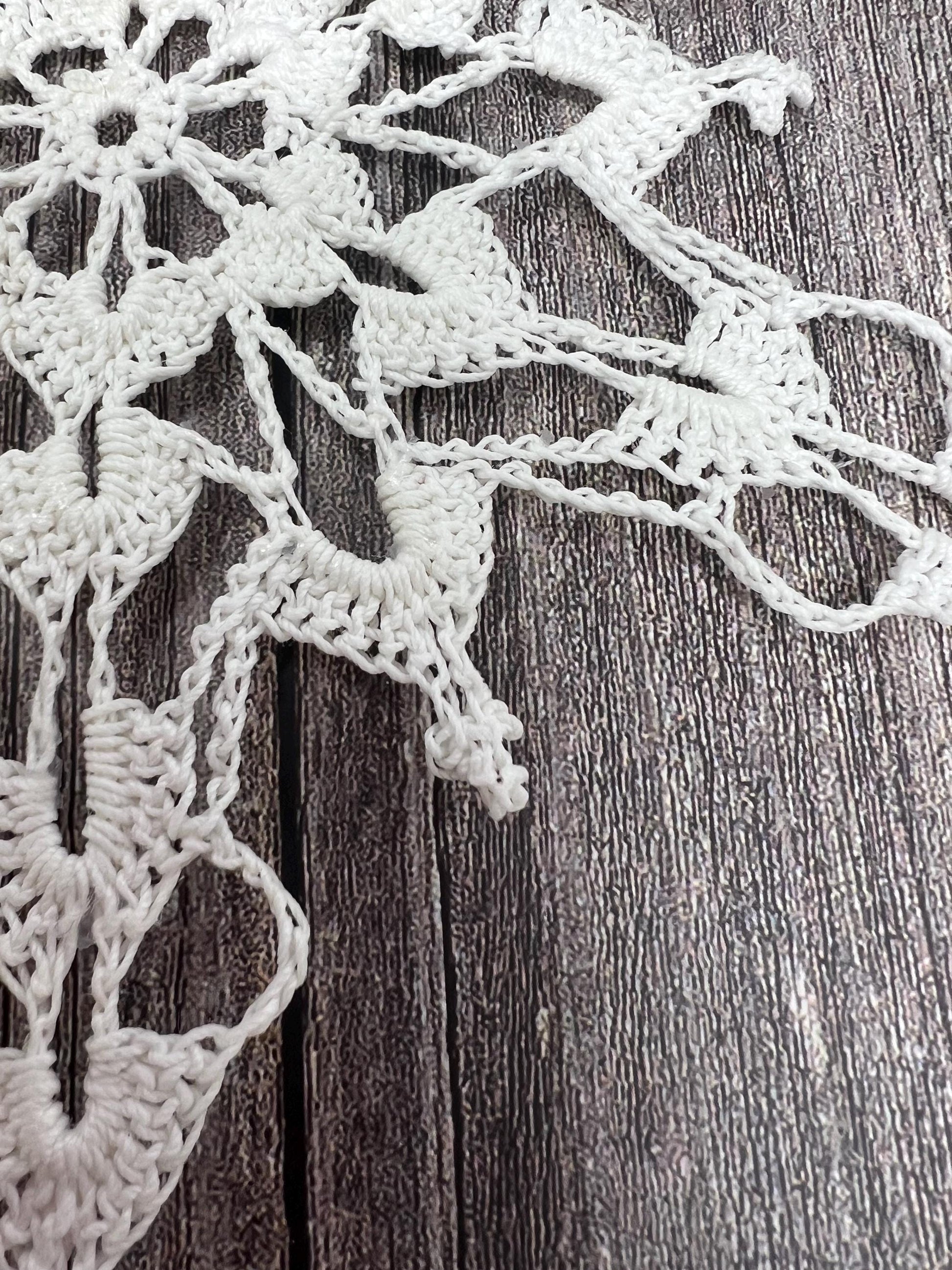 macro photo of intricate detail of crochet lace snowflake
