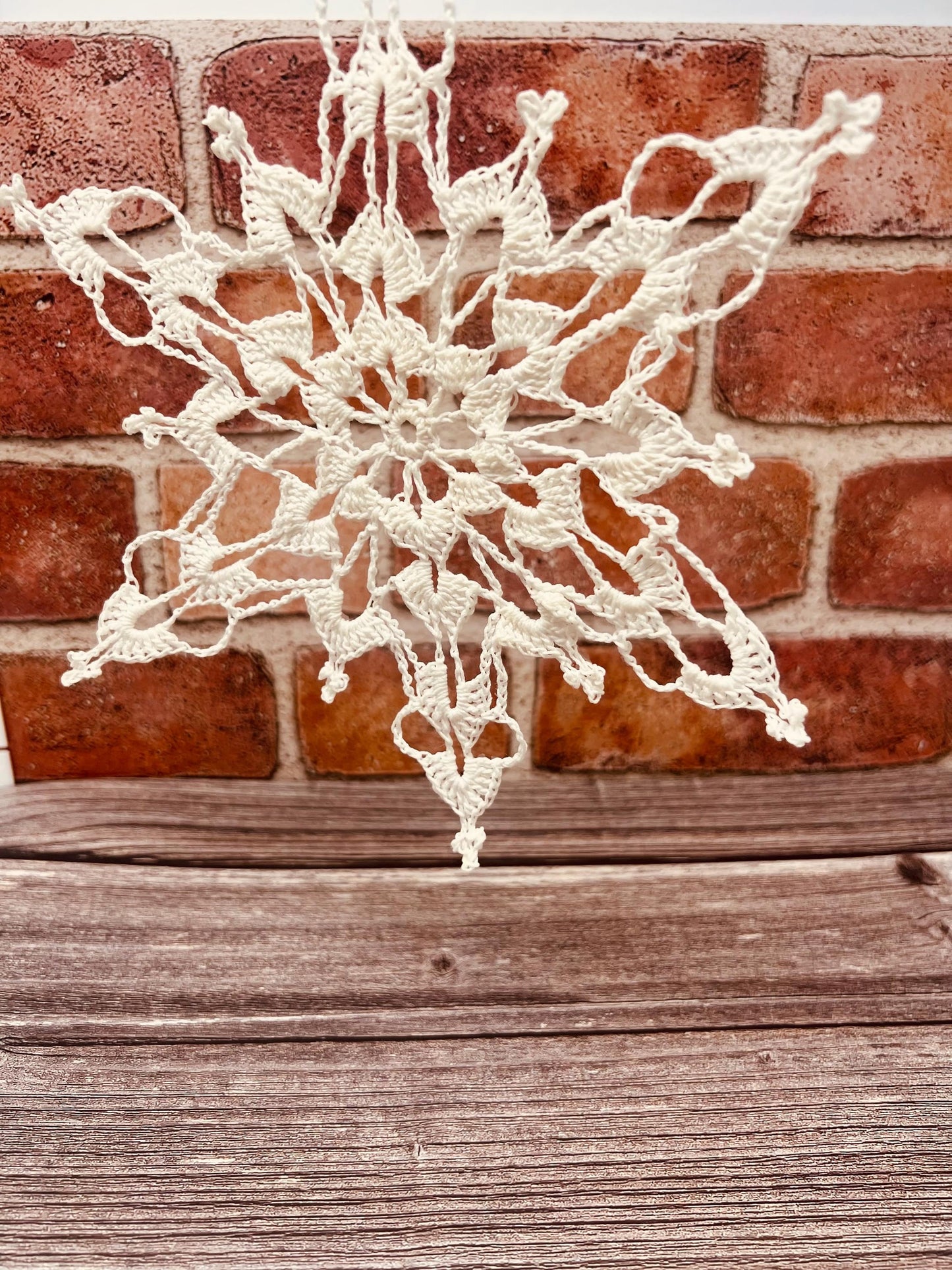 8" lace crocheted white snowflake stiffened to show intricate detail. strung for easy display